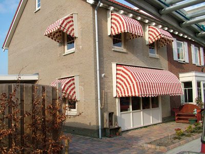 Huis met rood-wit-gestreepte markiezen