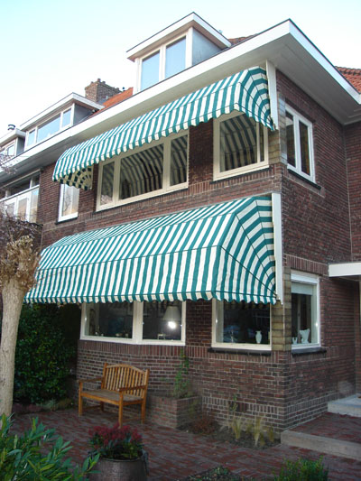 Huis met groen-wit-gestreepte markiezen
