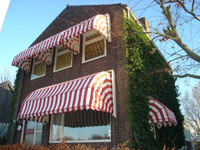Huis met rood-wit-gestreepte markiezen