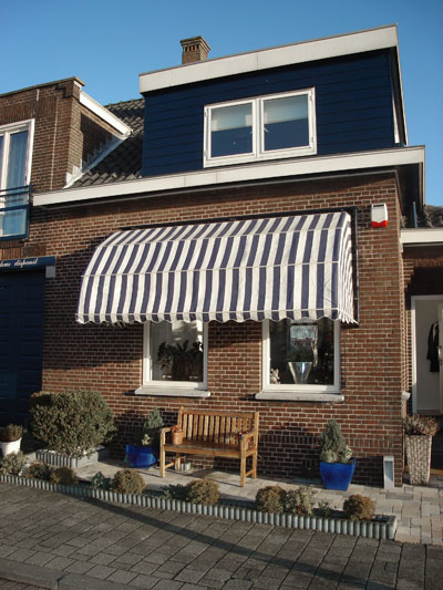 Huis met blauw-wit-gestreepte markies